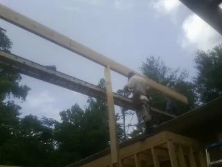 Carpenter setting a ridge beam over a new addition frame — Ice Dam Removal by Roofing Brothers in Du Pont