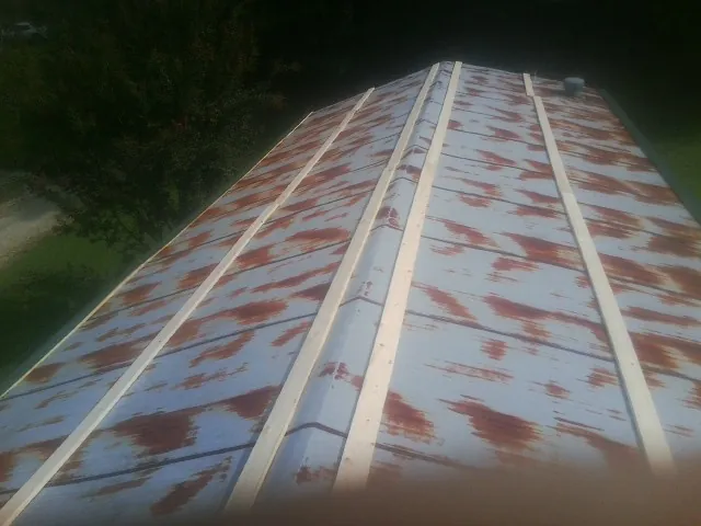 Rusted metal roof panels with new wood purlins before replacement — Storm Damage Roof Repair in Du Pont by Roofing Brothers