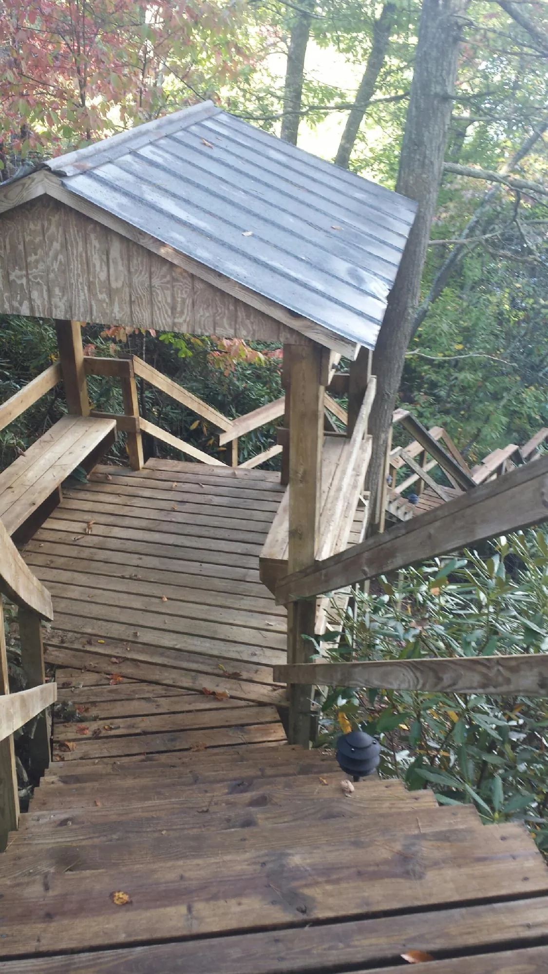 Metal roofed shelter over wooden steps on a wooded walkway — Skylight Repair & Installation work by our crew in Du Pont