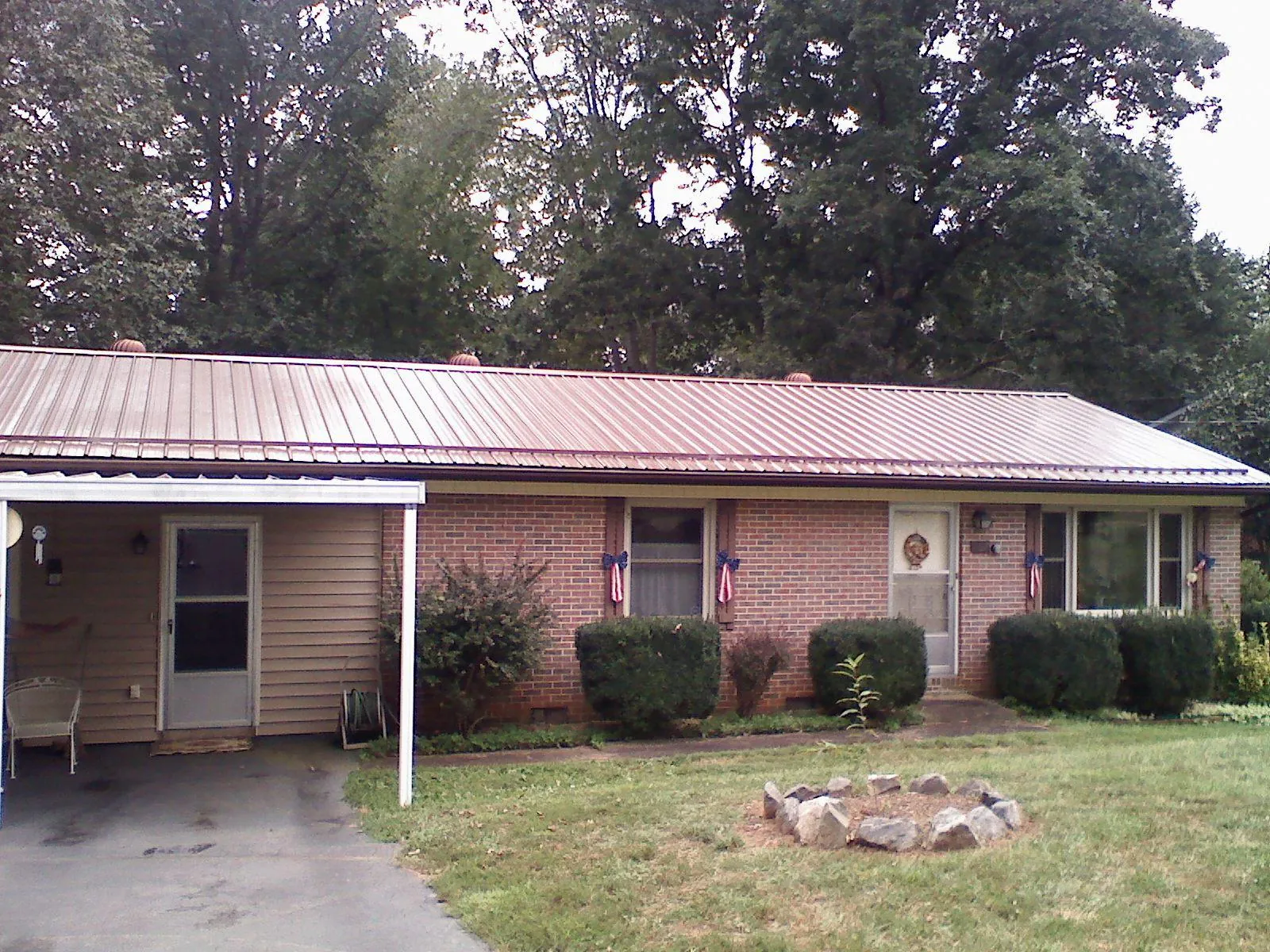 Bronze metal roof and carport on a brick ranch home — Roof Repair work by our crew in Du Pont